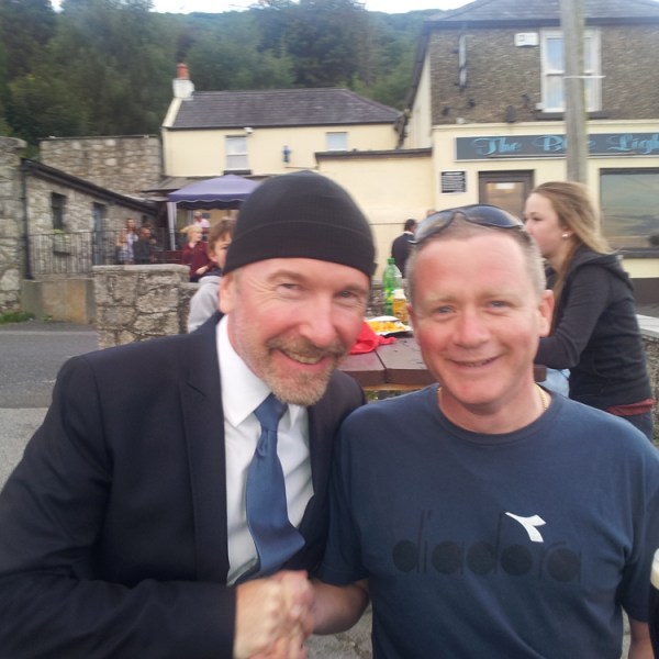 The Edge standing in front of a building