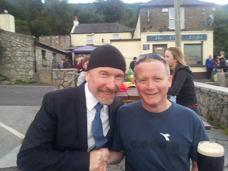 The Edge standing in front of a building