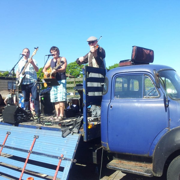 a group of people standing in front of a blue truck