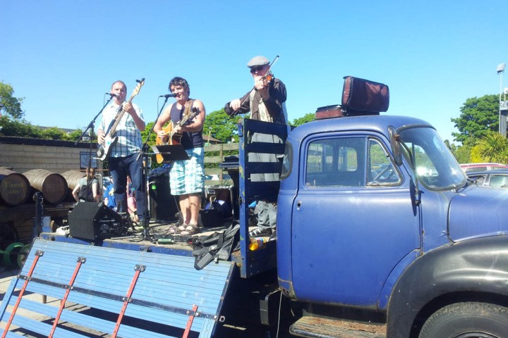 a group of people standing in front of a blue truck