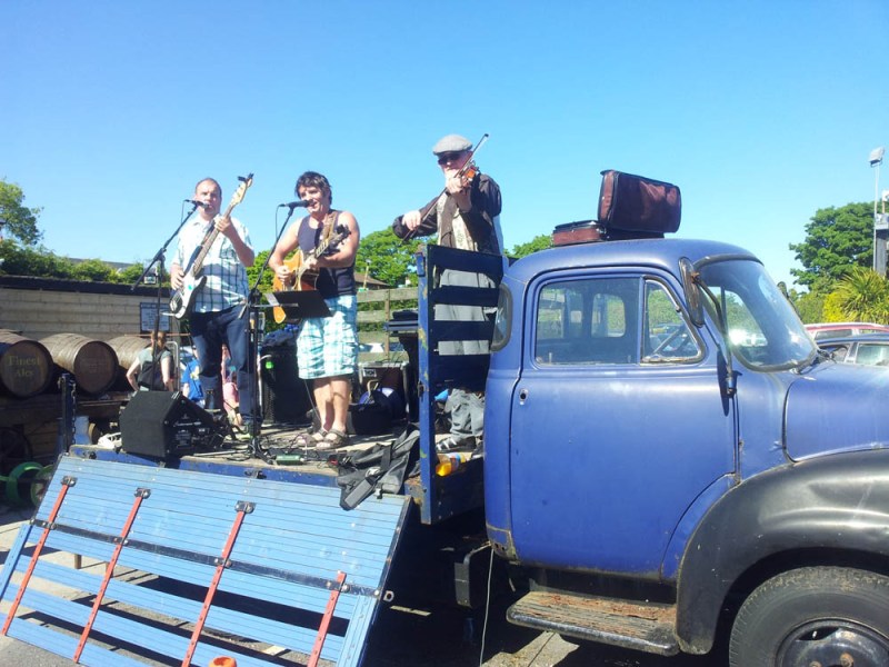 a group of people standing in front of a blue truck
